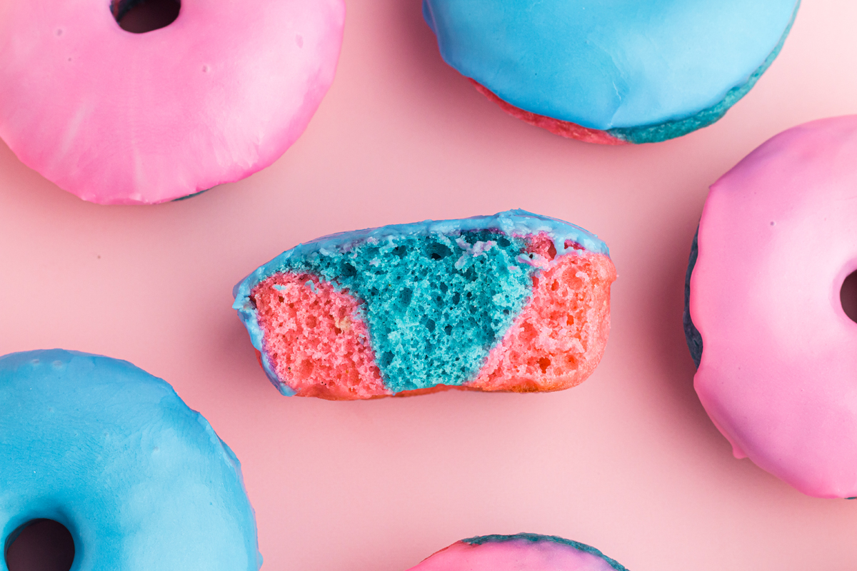 landscape orientation, half donut in the middle to see inside, surrouned by 5 other donuts but you can only see parts of the other donuts, pink top left, blue top right, pink middle right, pink bottom right a bit towards the middle, blue bottom left